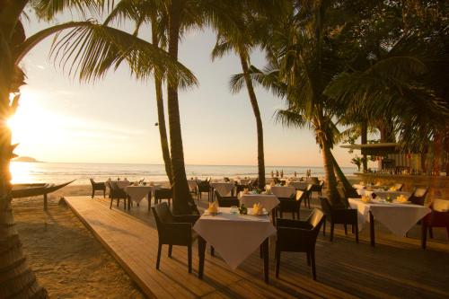 a restaurant on the beach with palm trees at Barali Beach Resort Koh Chang in Ko Chang