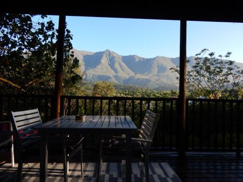 a table and chairs on a porch with mountains at Mountain View Swellendam in Swellendam