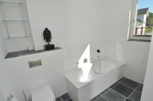 a white bathroom with a sink and a mirror at Ostseeresidenz Sassnitz - Penthouse 20 mit Sauna, Balkon, Meerblick in Sassnitz