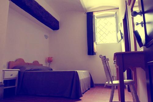 a bedroom with a bed and a window at Agriturismo Il Frantoio Di Colle Alberto in Montale