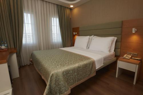 a hotel room with a bed and a telephone at Life Corner Hotel in Izmir
