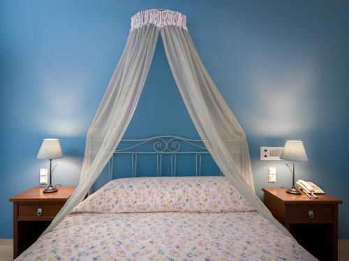 a bedroom with a bed with a canopy and two night stands at Zephyros Hotel in Kamari