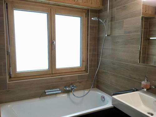 La salle de bains est pourvue d'une baignoire et d'un lavabo. dans l'établissement Grain d'Or - Studio 007, à Verbier