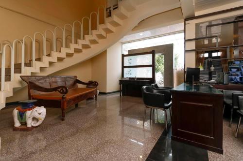 a living room with a staircase and a table and chairs at RedDoorz Plus near Halim Perdanakusuma 2 in Jakarta
