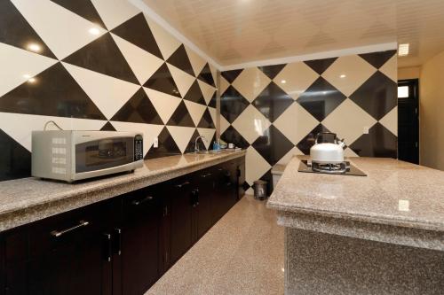a kitchen with a counter with a microwave on it at RedDoorz Plus near Halim Perdanakusuma 2 in Jakarta