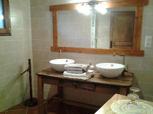 uma casa de banho com 2 lavatórios e um espelho em Le Martinou em Le Cayrol