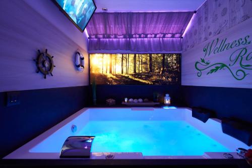 a large bath tub in a purple room with at Beverly Weekend in Butgenbach