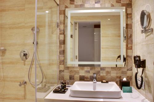 a bathroom with a sink and a shower at Ramada Encore Domlur Bangalore in Bengaluru