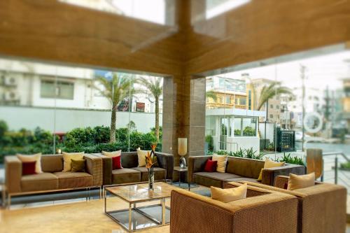 a living room with couches and a table at Ramada Encore Domlur Bangalore in Bengaluru