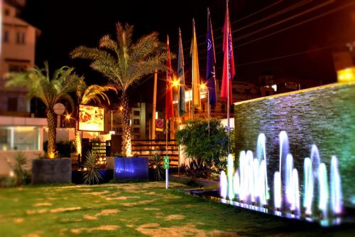 a fountain in front of a brick wall at night at Ramada Encore Domlur Bangalore in Bengaluru