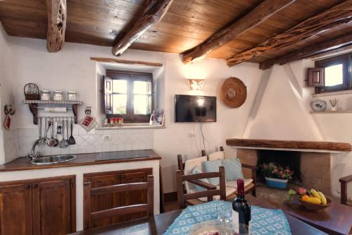 a kitchen with a table and a fireplace at Antiche Case in Pietra in Baunei
