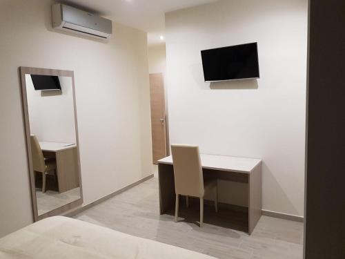 カッシーノにあるLa Suiteのデスク、壁掛けテレビが備わる客室です。
