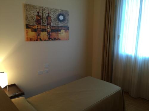 ein Zimmer mit einem Bett und einem Gemälde an der Wand in der Unterkunft Locanda Corte Girlanda in Verona