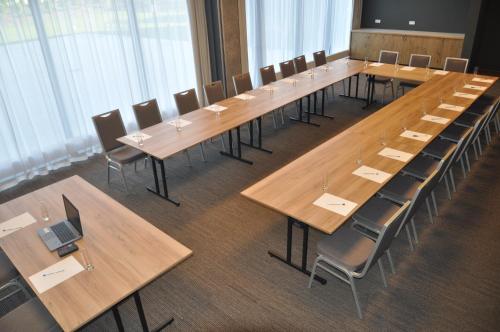 a large conference room with wooden tables and chairs at Ibis Poznan Polnoc in Suchy Las