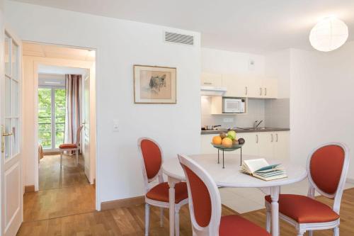 une cuisine et une salle à manger avec une table et des chaises dans l'établissement MÉDICIS HOME DIJON LES PETITES ROCHES, à Dijon