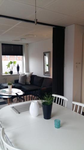 een woonkamer met een bank en een tafel bij Den Skaldede Kok Guesthouse in Bindslev