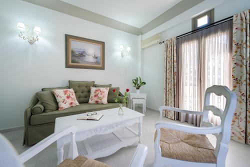 a living room with a couch and a table and chairs at Zephyros Hotel in Kamari