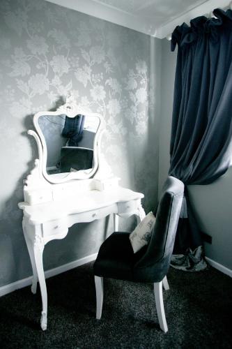 a white desk with a mirror and a chair at Stirk House Hotel in Clitheroe