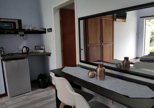 a room with a table and chairs and a large mirror at Gemstone Guest House in Klerksdorp