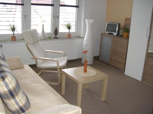 uma sala de estar com um sofá, uma mesa e uma televisão em Zimmervermietung Schönfließer Stuben auch für Monteure em Eisenhüttenstadt