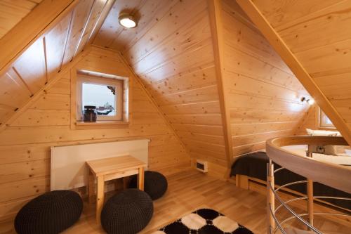 a cabin with a loft with a table and chairs at Pokoje Gościnne BENITA in Zakopane