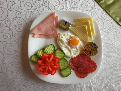 Un plato de desayuno con huevos, carne y verduras. en Pension Club Montana, en Campina