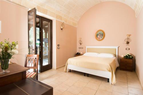 a bedroom with a bed and a table at Masseria Grottella in Avetrana
