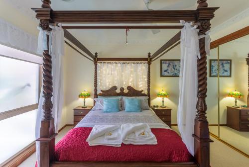 ein Schlafzimmer mit einem Himmelbett und Handtüchern darauf in der Unterkunft Fairy Wren Cottage Country to Coast Retreat in Wallington