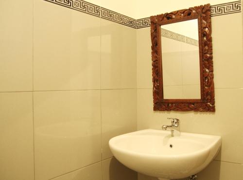 a white bathroom with a sink and a mirror at Sedana Jaya in Ubud