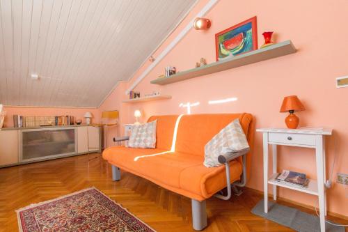 a living room with an orange couch and a table at Moonshine apartment with magnificent view in Šibenik