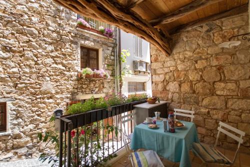 a patio with two tables and a stone wall at Antiche Case in Pietra in Baunei