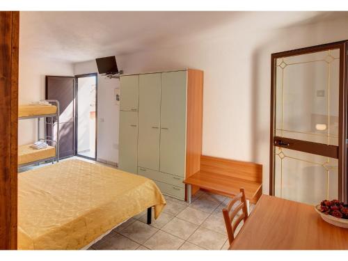 a room with a table and a green cabinet at Hotel Pedra Niedda in Budoni
