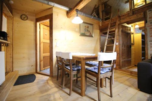 a dining room with a table and chairs in a cabin at Ferienhaus Anno Dazumal, wie zu Opa`s Zeiten in Klingenthal