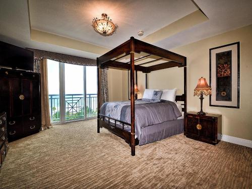 a bedroom with a canopy bed and a large window at Aqualea 504 in Clearwater Beach
