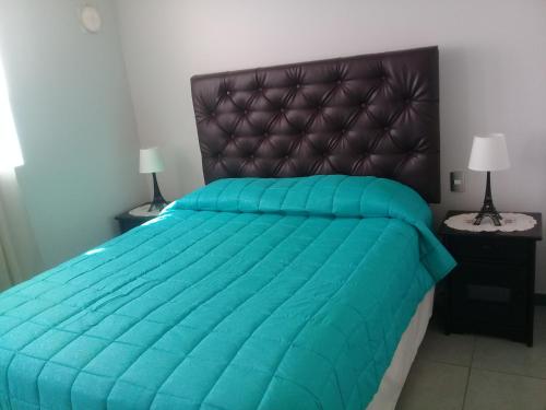 a bedroom with a large bed with a blue comforter at Apartamento Bahía Horizonte in Coquimbo