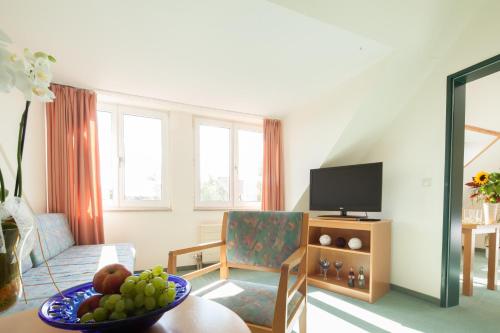 a living room with a bowl of fruit on a table at Apart Hotel Gera in Gera