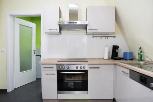 多森海姆的住宿－海德堡夏洛特度假屋，厨房配有白色橱柜和炉灶。