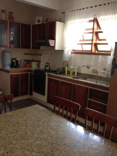 a kitchen with wooden cabinets and a counter top at Morada Guaruja in Palhoça