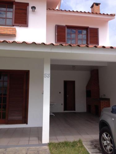 a white house with a large patio in front of it at Morada Guaruja in Palhoça