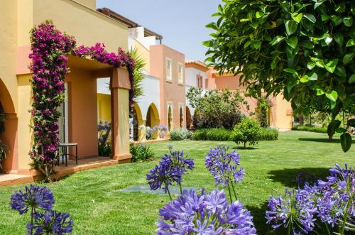 a garden with purple flowers in a yard at Jardim da Meia Praia Resort in Lagos