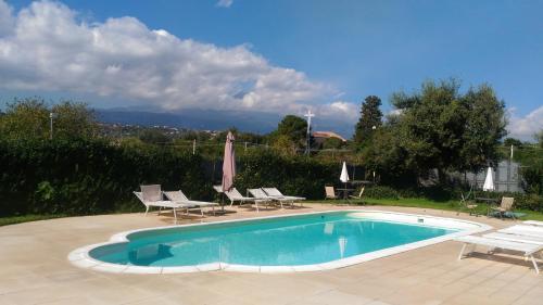 a swimming pool with chairs and a umbrella at Case Vacanze Residence Trinacria in Acireale