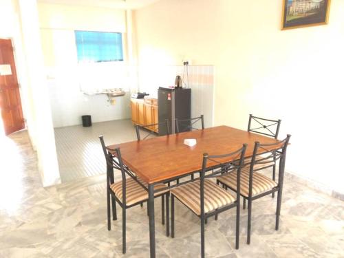 a dining room table with chairs and a refrigerator at Ocean view resort in Port Dickson