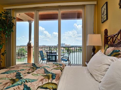 una camera da letto con un letto e un balcone con vista di Harborview Grande 604 a Clearwater Beach