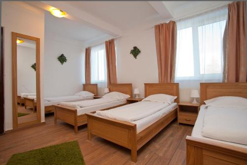 a room with four beds and a mirror at Pension Club Montana in Campina