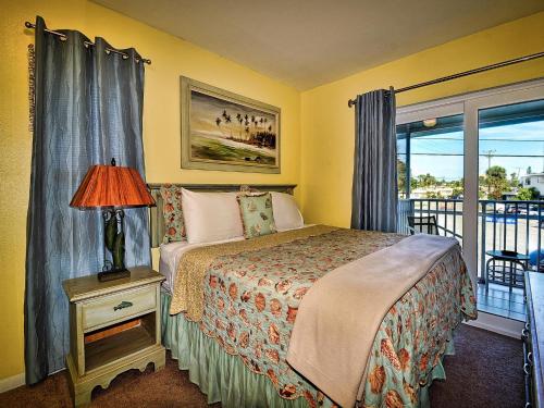 een slaapkamer met een bed en een raam met een balkon bij Island Escape 201 in Clearwater Beach