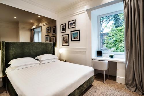1 dormitorio con cama, escritorio y ventana en The Shire Hotel, en Roma