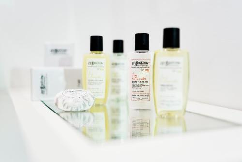 a group of four bottles of hair products on a shelf at The Shire Hotel in Rome