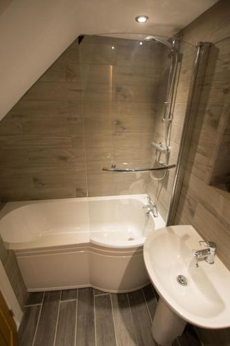a bathroom with a tub and a sink and a toilet at Red Rose Cottage in Cockermouth