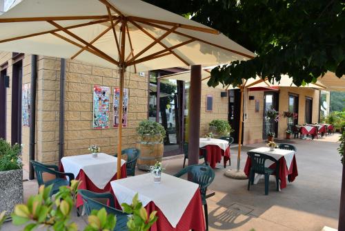 ヴェローナにあるLocanda Corte Girlandaのテーブルと椅子、傘が備わるレストラン