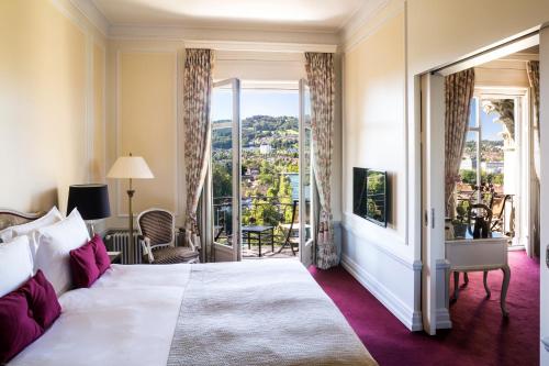 a bedroom with a large bed and a balcony at Hotel Bellevue Palace Bern in Bern